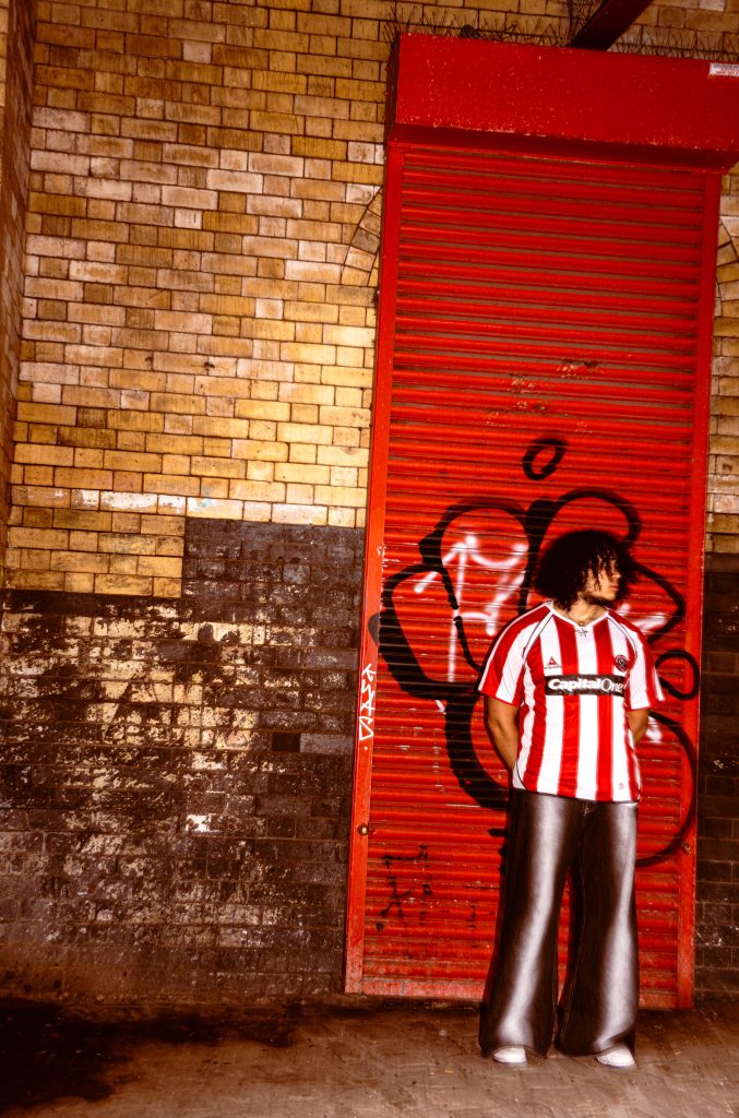 Samuel Virgo standing beside a red doorway