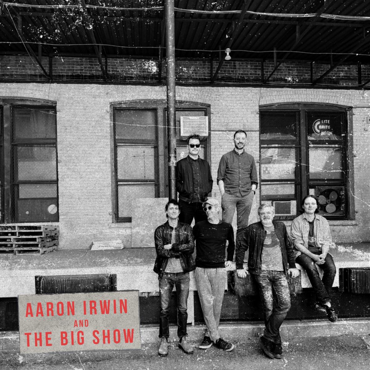 The Big Show album cover shows Aaron Irwin’s six-piece ensemble outside a brick building in a black-and-white photograph, with red lettering.