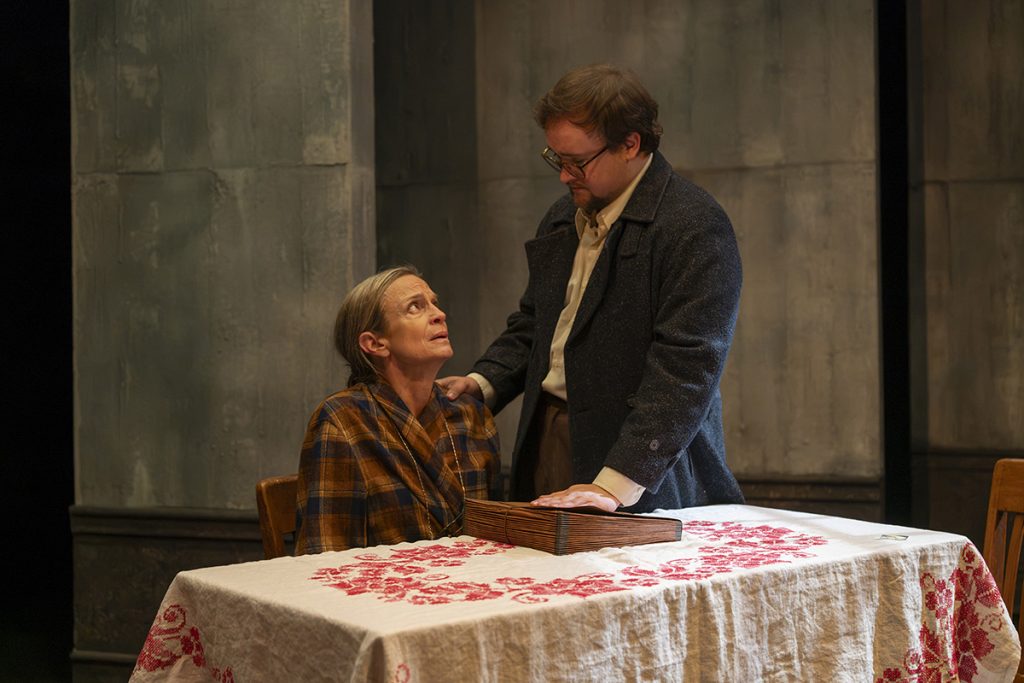 Rebecca Jordan seated at a table with Tristan Odenkirk in Shattered Globe Theatre’s Vladimir.